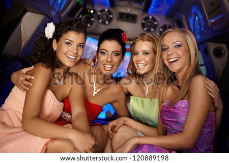 Beautiful young girls having party in limousine, smiling.