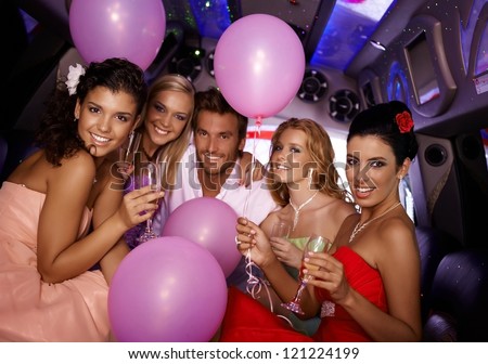 Attractive young people having party in limousine.