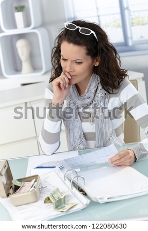 Troubled woman calculating budget at home, money, bills and finances.