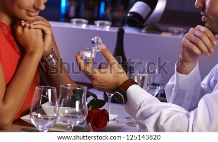 Romantic dinner with engagement ring. Young man proposing to woman.