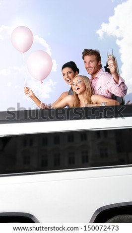 Young people having party in limousine, smiling, having fun.