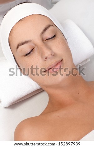 Young woman laying eyes closed in beauty salon, with clean fresh face.