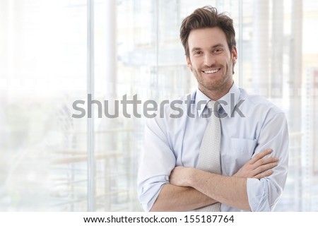 Portrait Of Handsome Confident Young Businessman Standing Arms Crossed, Smiling Happy, Looking At Camera.