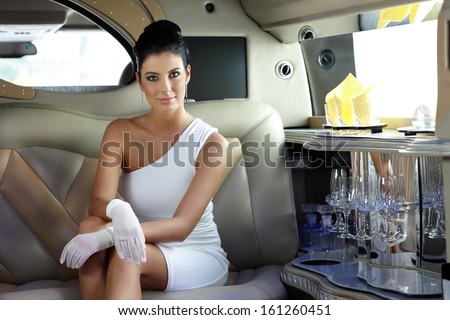 Beautiful smart woman sitting in limousine.