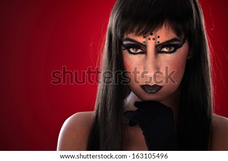 Young woman with professional black makeup and evil eyes.