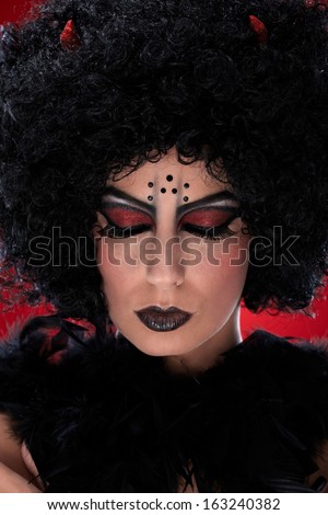 Closeup portrait of devil woman with closed eyes.
