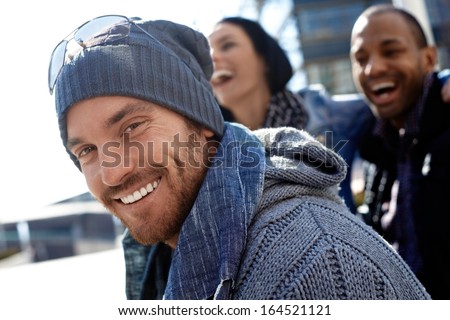Outdoor Portrait Of Happy Young Man Wearing Scarf And Smiling At Camera.