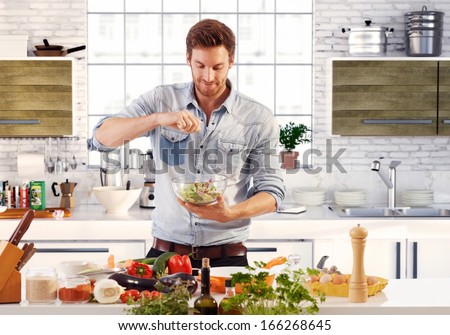 Handsome Man Cooking At Home Preparing Salad In Kitchen.