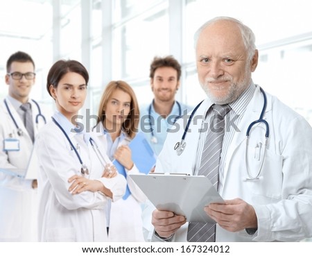 Portrait of aged male doctor teaching medical students.