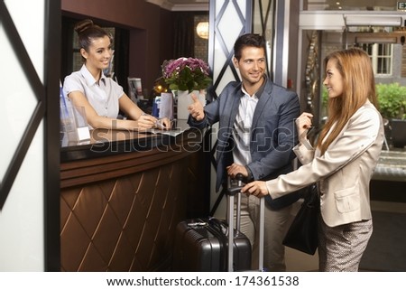 Young couple upon arrival at hotel reception.