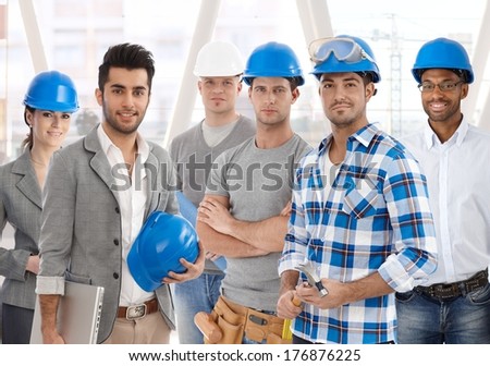 Group of diverse people from building industry: architects, managers, workers posing together for a team portrait.