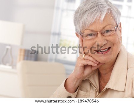 Closeup portrait of elderly woman looking at camera, smiling.