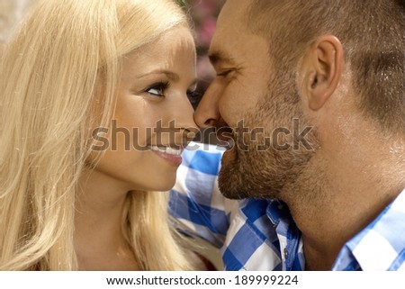 Close up of happy romantic young couple outdoor. Attractive blonde, smiling woman and stubbly handsome man.