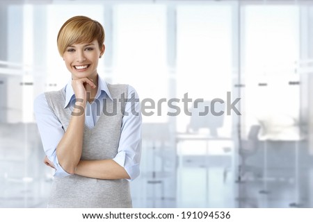 Portrait of happy female office worker at office. Space on right.