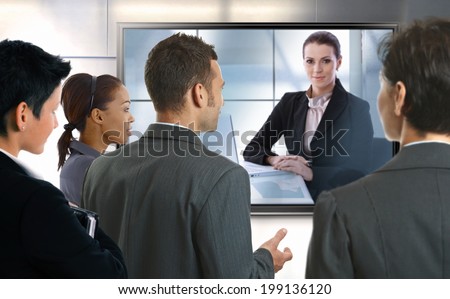 Young businesspeople and businesswoman having video call at office. LCD display.