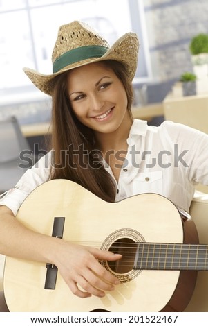 Portrait of happy young female guitar player with instrument.