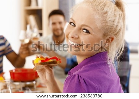 Closeup photo of beautiful young woman dining with friends, smiling happy, looking at camera.