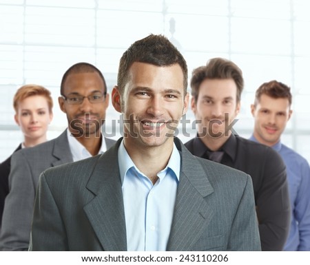 Portrait of happy young businessman and young businessteam at office.