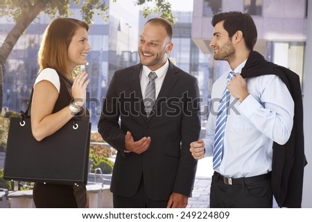 Happy businessman introducing new partner to attractive female colleague, outdoors. Suit and tie.