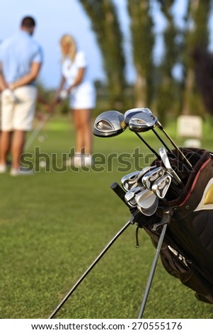 Closeup photo of professional golfing kit on golf course, on green grass.