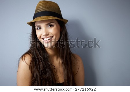 Portrait of beautiful young woman smiling happy, wearing straw hat.