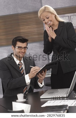 Businesswoman happy as partner signing contract, rubbing hands excited.