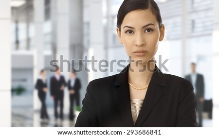 Serious attractive asian businesswoman in suit at corporate lobby. Copy space.