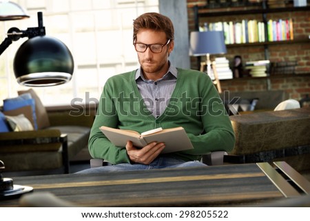 Young man reading book at old-fashioned home.