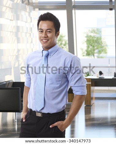 Portrait of confident young asian businessman at office.