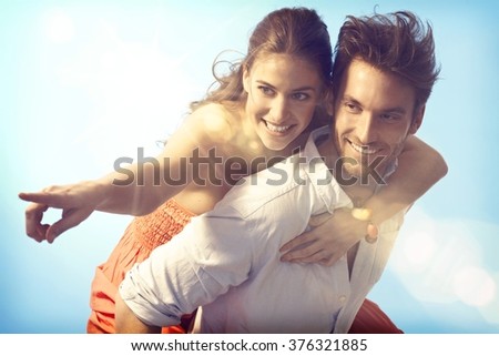 Romantic loving couple piggyback on summer holiday.