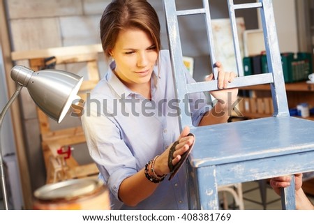 Young woman renewing chair, grinding.