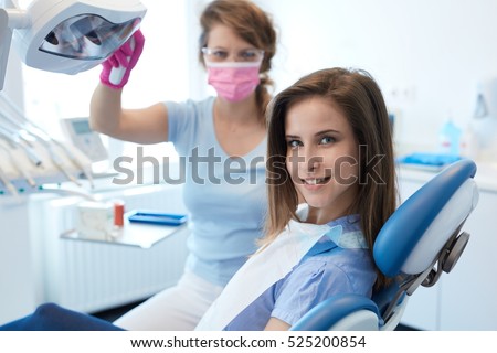 Young woman having dental check-up in dentist\'s office, smiling, looking at camera.