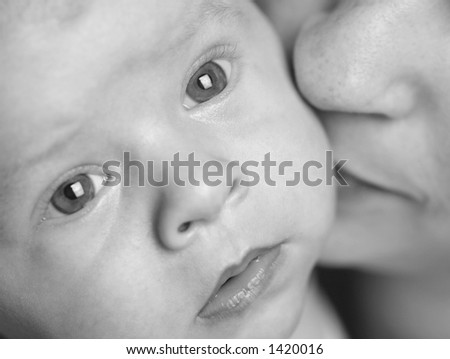 Baby and his mother are together in a very intimate moment. The mother is kissing her son. The baby is 3 months old.