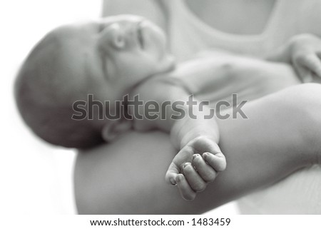 A baby is sleeping in the secure hands of his mother.