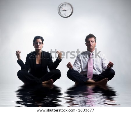 Young business people in an abstract office environment are sitting in yoga lotus-pose and relaxing.