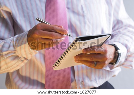 Businessman holds his desk calendar and a pen.