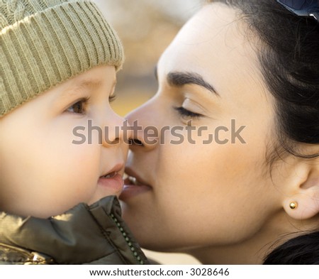 Mother kisses her one and a half year old child.