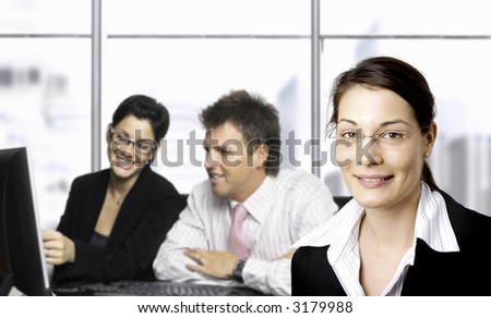 Young businesspeople are working in the office. Selective focus is placed on the woman in the foreground.