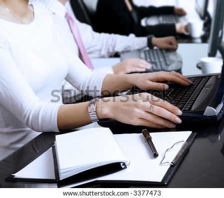 Close-up os human hands. Young office workers are typing on keyboards in front of their office computers.