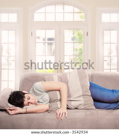 Young woman sleeps on the couch in the livingroom.
