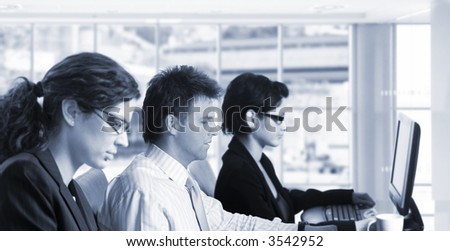 Young office workers are sitting in front of their computer screens.