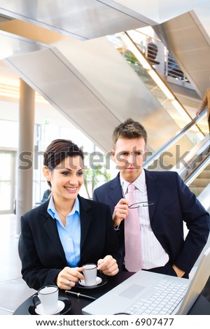 Business people working over a coffee table in the lobby.