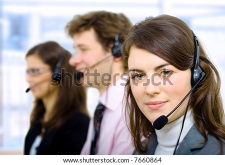 Customer service team working in headsets, smiling.