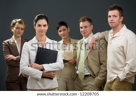 Businesswoman standing in front of his smiling team.