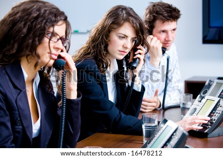 Young customer service operator team working at office, holding phone, calling, giving helpdesk support.