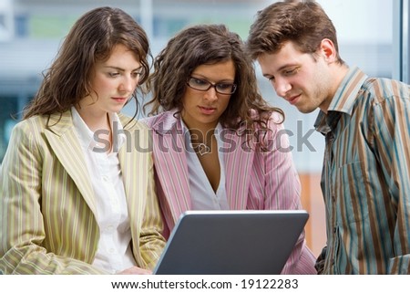 Young casual office workers having meeting at office, working in team together on laptop computer.