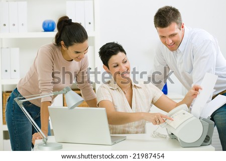 Team of happy office people working at office using fax.