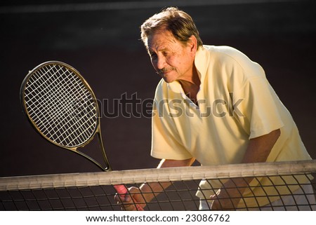 Active senior man in his 70s is playing tennis.