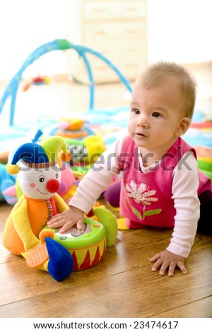 Baby girl (9 months) playing with soft toys at home. Toys are property released.