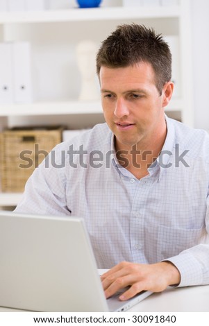 Business man working on laptop computer at home.